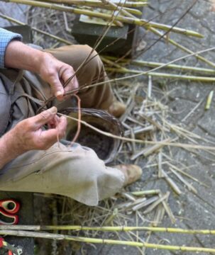 Artisan hands weaving with natural reeds in a traditional workshop in Calabria, southern Italy