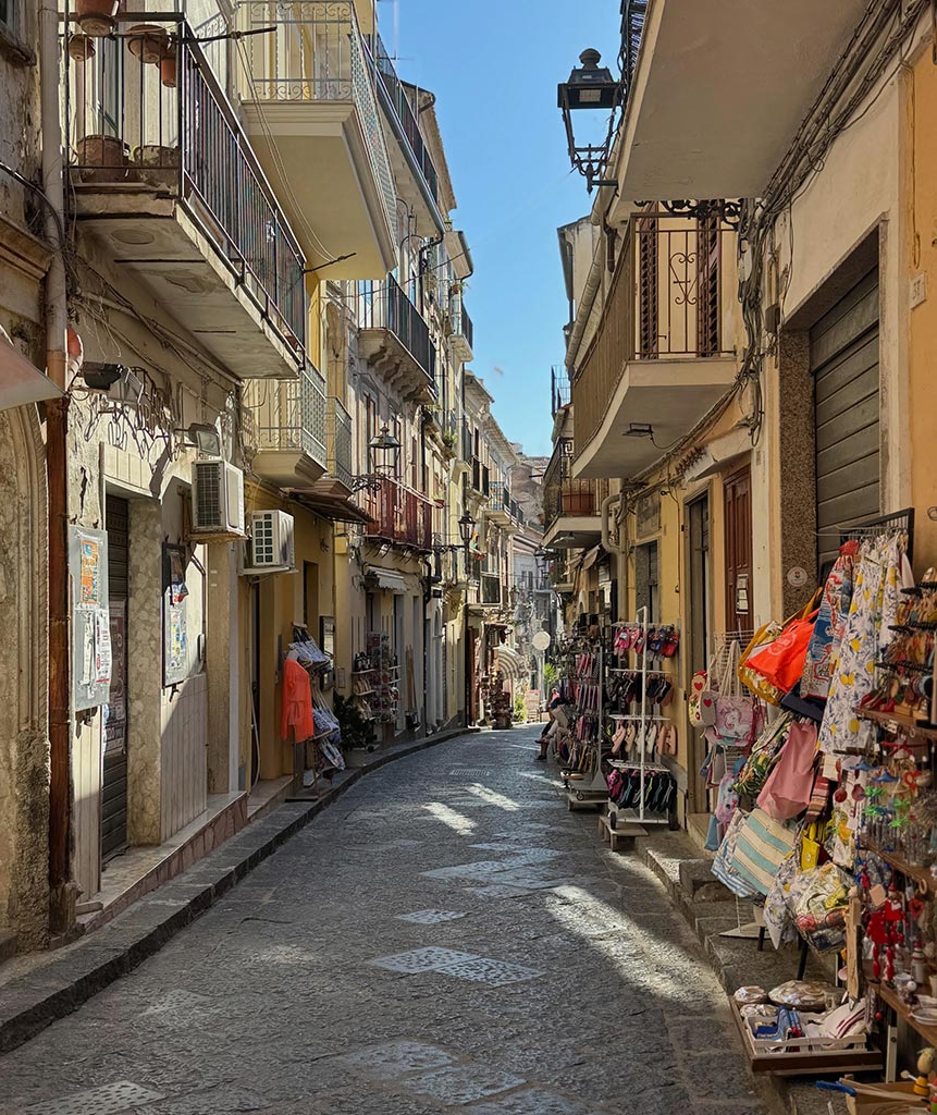 Historic street in Pizzo Calabro with balconies and local shops Calabria Italy Photo